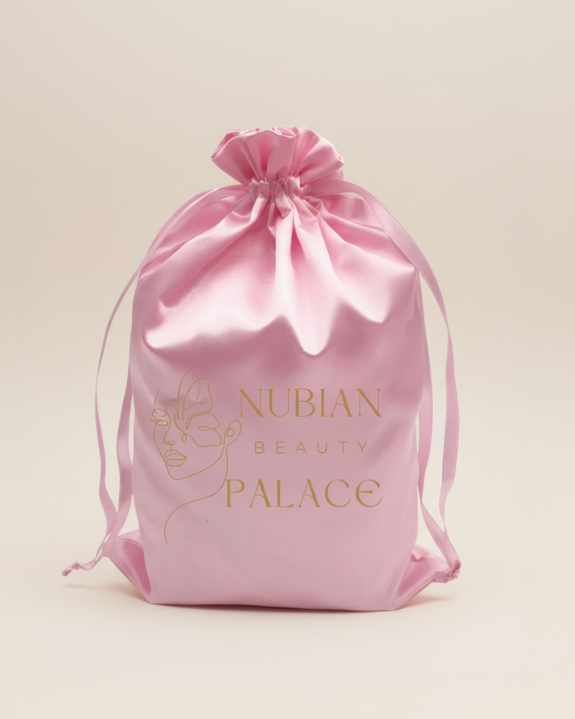 Pink silk drawstring bag with 'Nubian Beauty Palace' logo on a white background